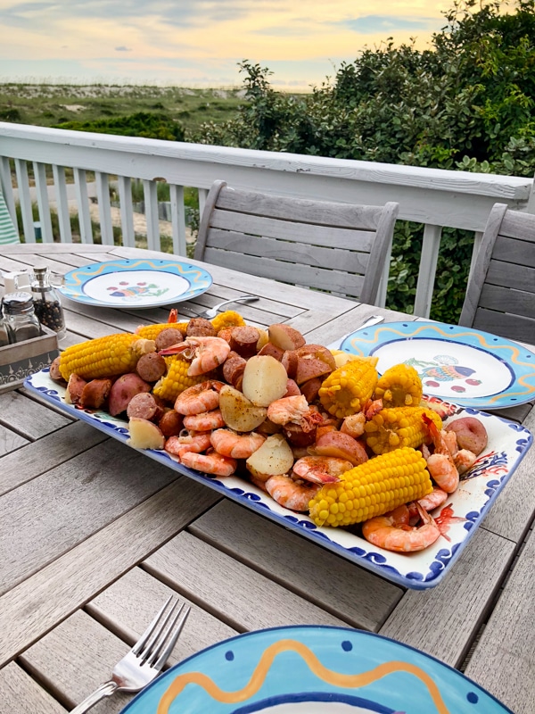 low country boil food on a platter with beach view