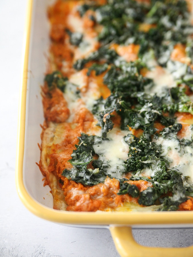 pumpkin, goat cheese and kale lasagna in a yellow casserole dish