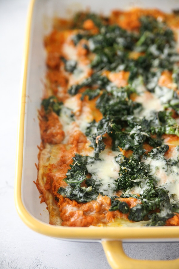 pumpkin, goat cheese and kale lasagna in a yellow casserole dish