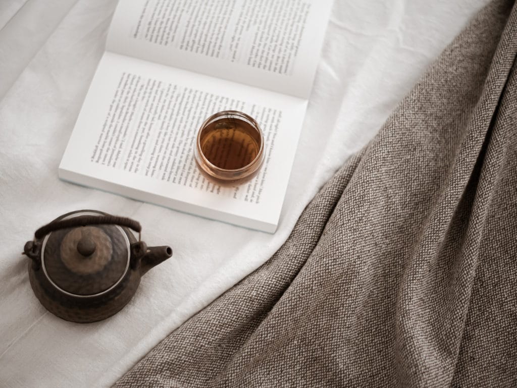 pot of tea next to a book