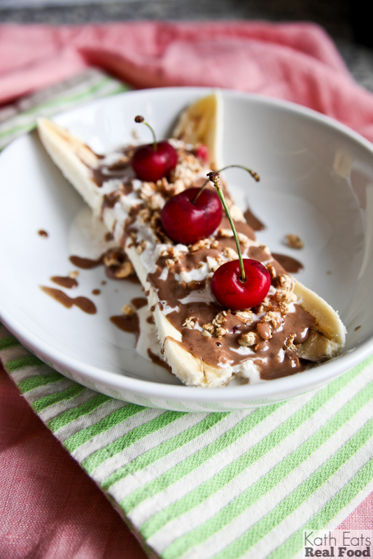 overnight oats banana split with fresh cherries and a peanut butter chocolate sauce