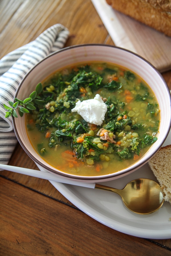 pea soup with greek yogurt and herbs in a pink bowl