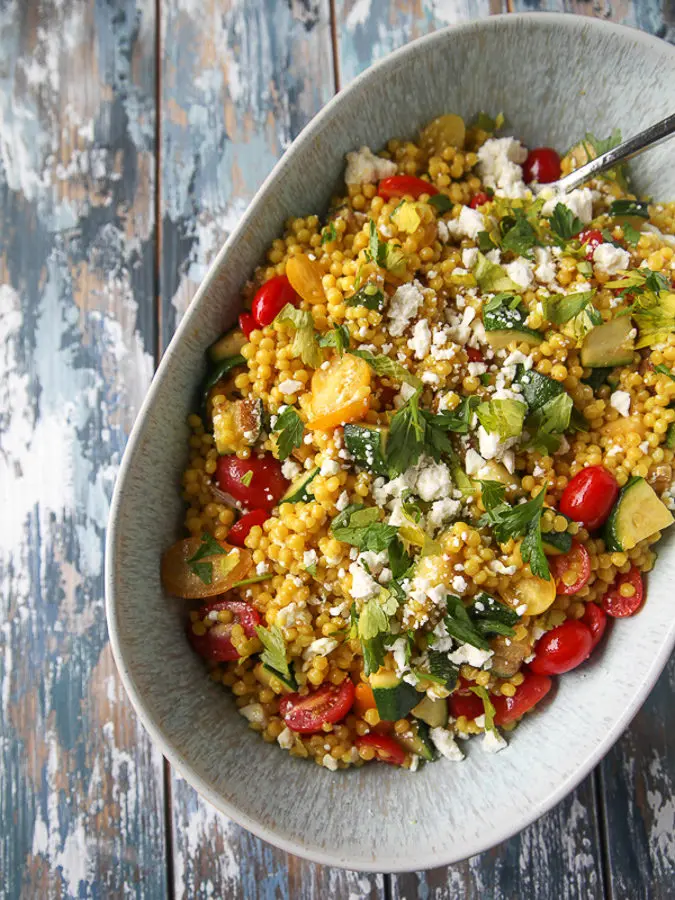 Couscous salad with zucchini, tomatoes, parsley, and feta