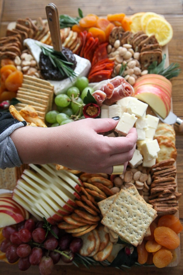 Charcuterie Board hand enjoying cheese