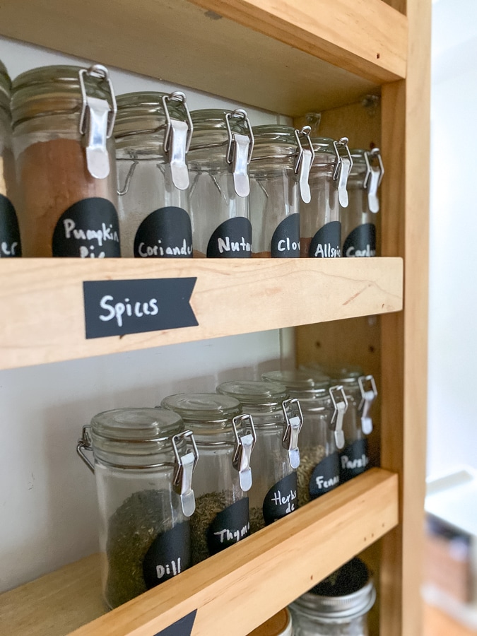neatly organized spice jars with chalk board labels