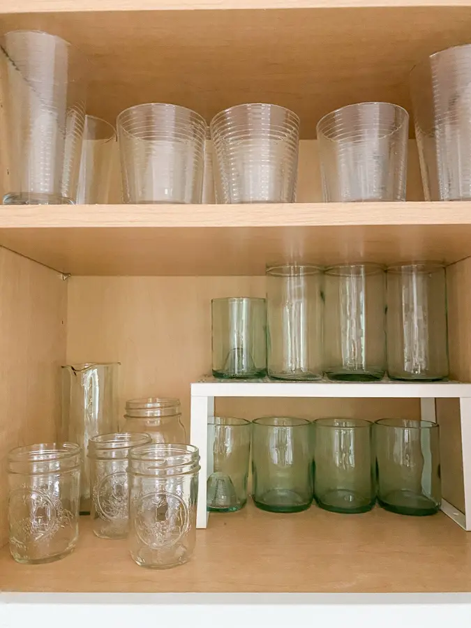 glasses in a cabinet using a shelf riser