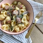 Orecchiette with Sausage and Mushrooms in a pink bowl and gold fork