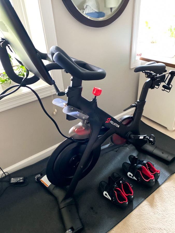 Peloton bike with shoes on a mat