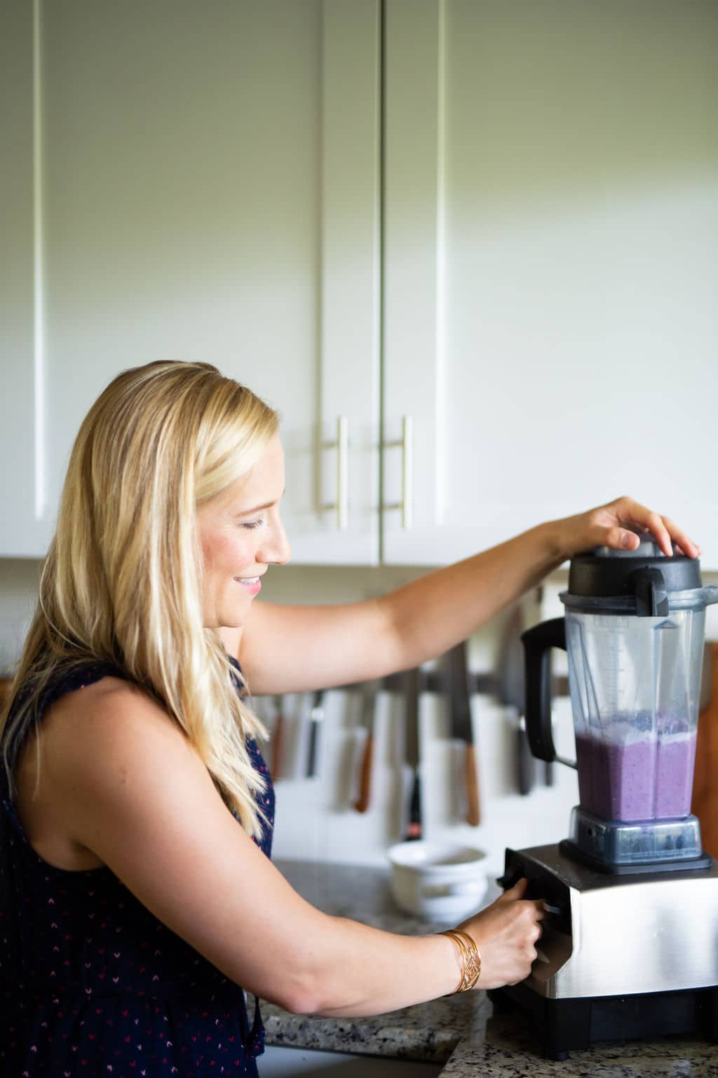 Kath Younger blending purple berry smoothie in a Vitamix blender.
