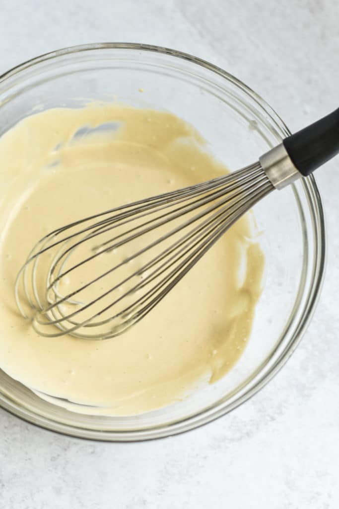 tahini dressing in a mixing bowl with whisk