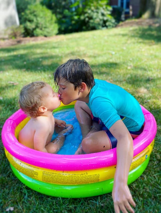 brothers in a kiddie pool kissing