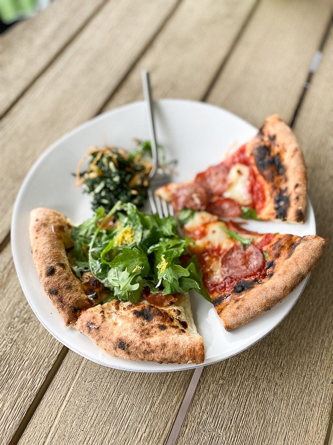 pizza slices with fresh arugula on white plate