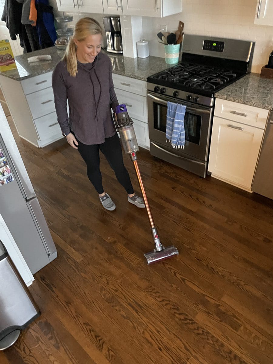 woman using Dyson cordless vacuum