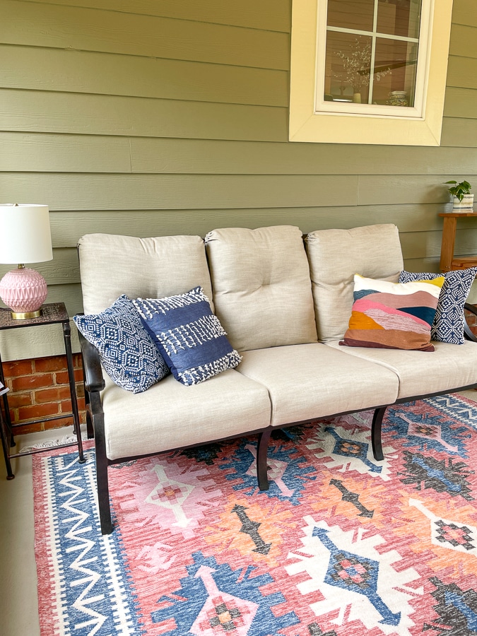 screened in porch with sofa and coral rug from west elm