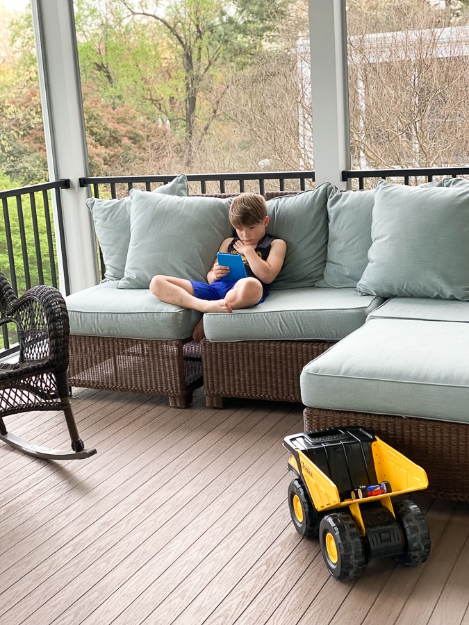 kid reading Kindle on couch | How To Raise Happy Kids In The Digital Age