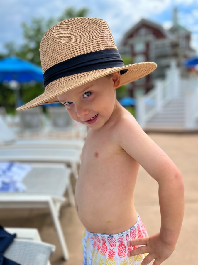 little boy posing with straw hat