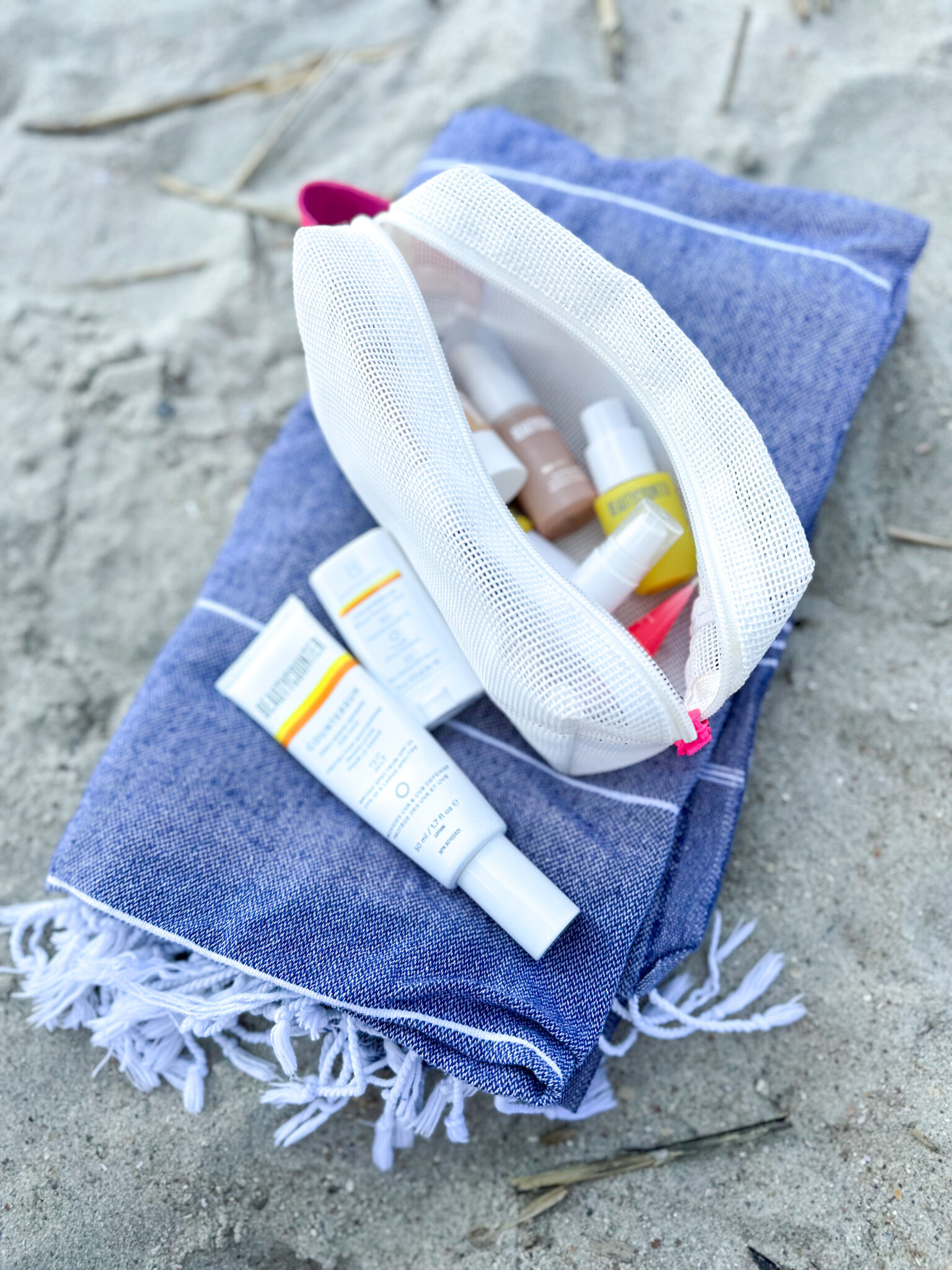 summer skincare tips: Beautycounter products on blue beach towel