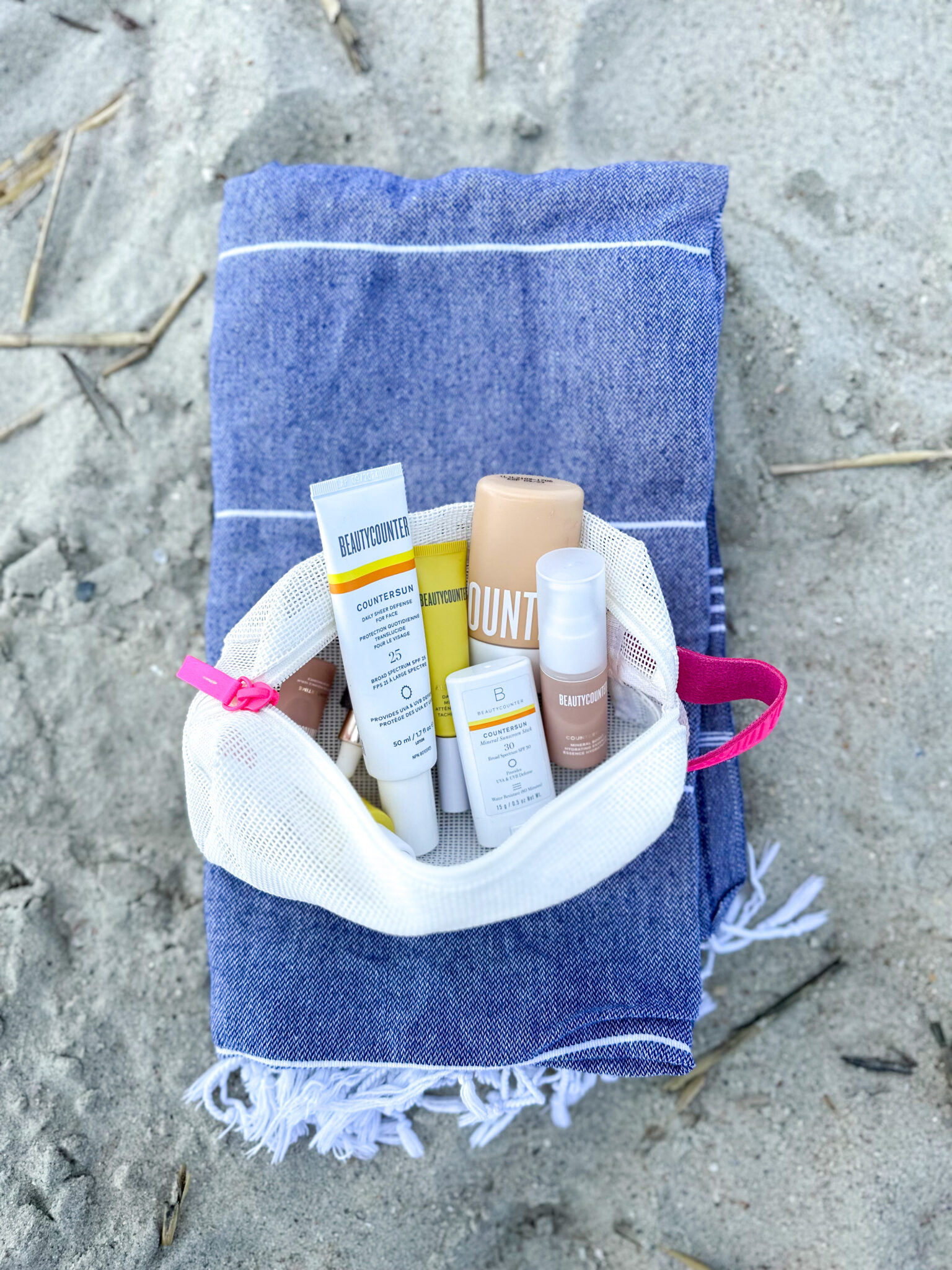 summer skincare tips: Beautycounter products on blue beach towel