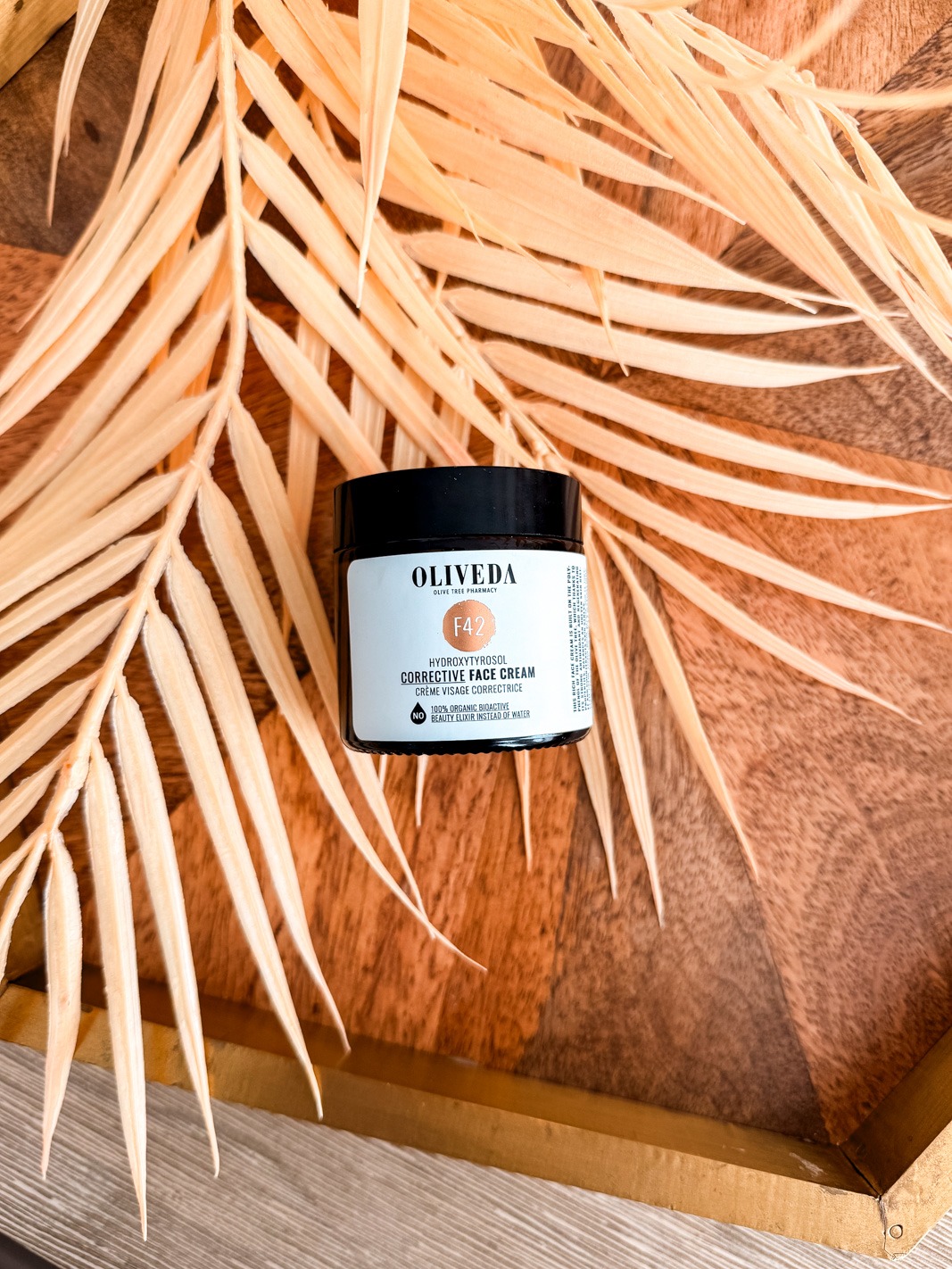 Oliveda F42 Corrective Face Cream on top of a palm leaf