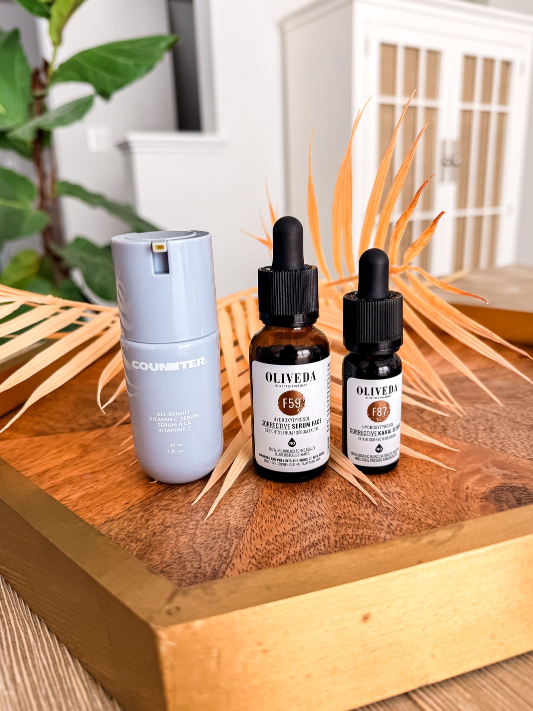 All Bright C Serum, Oliveda F59 Corrective Serum and F87 Kahai Serum on a wooden tray