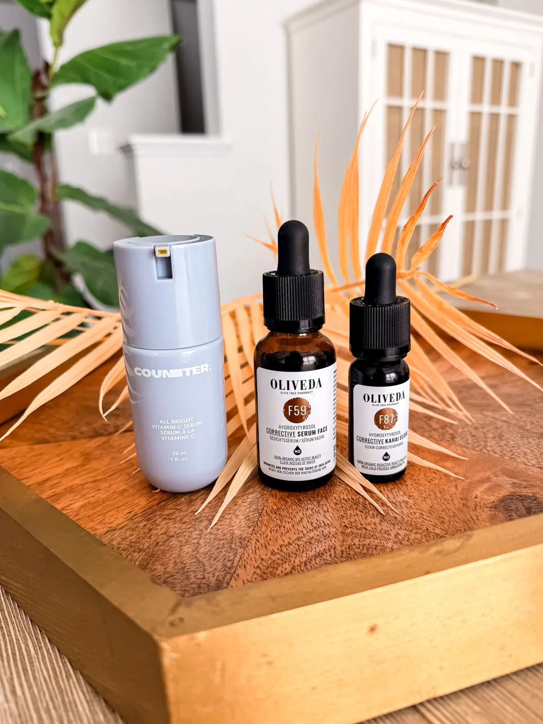 All Bright C Serum, Oliveda F59 Corrective Serum and F87 Kahai Serum on a wooden tray
