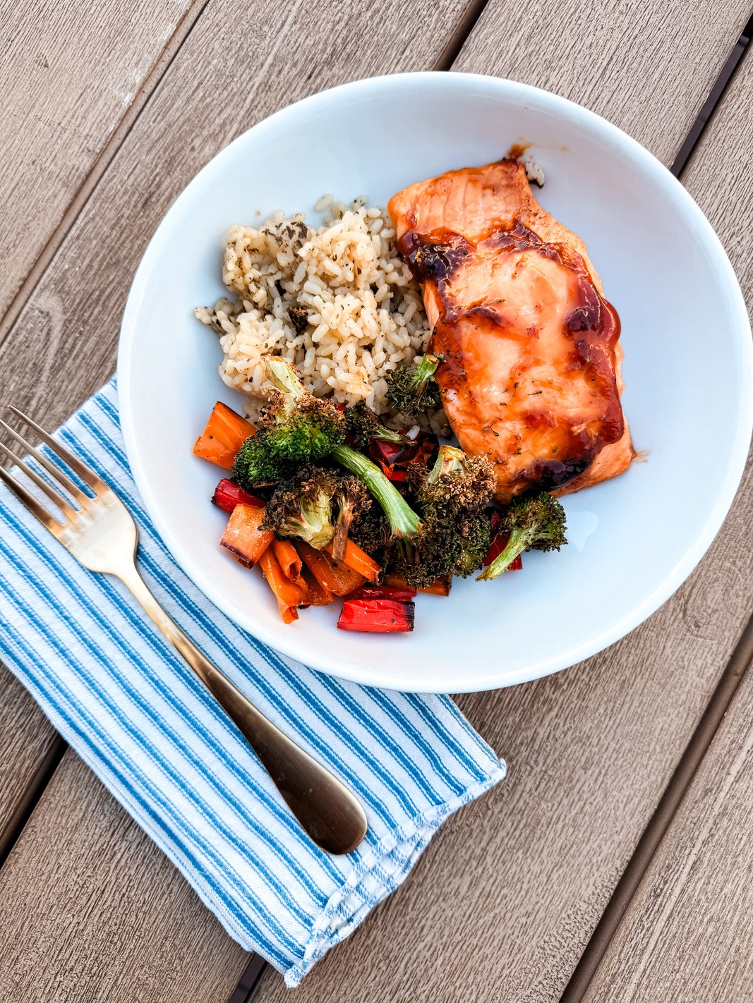 teriyaki salmon in a bowl with roasted broccoli, peppers and rice 