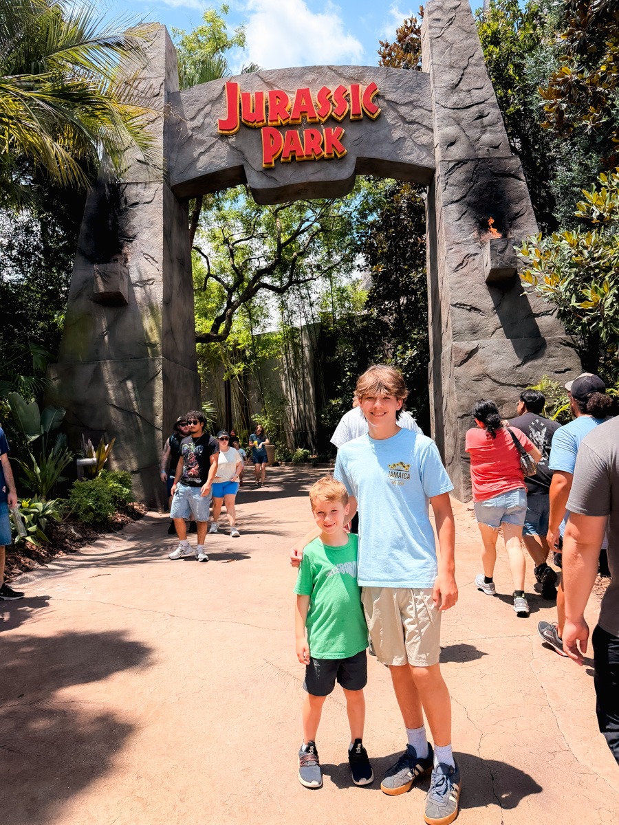 kids under Jurassic park sign at Universal Islands of Adventure