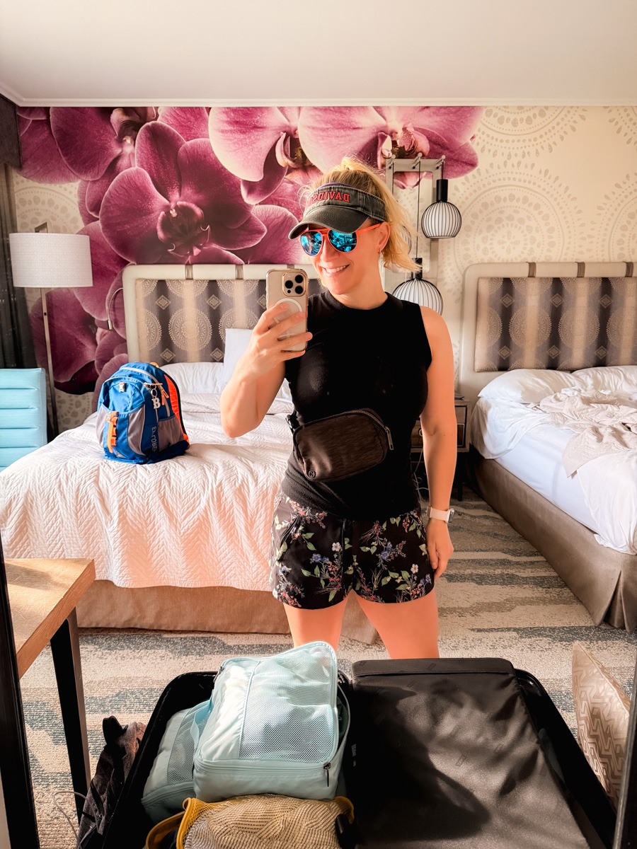 What to wear to Universal Islands of Adventure - Kath wearing a tank top, shorts, fanny pack, and visor