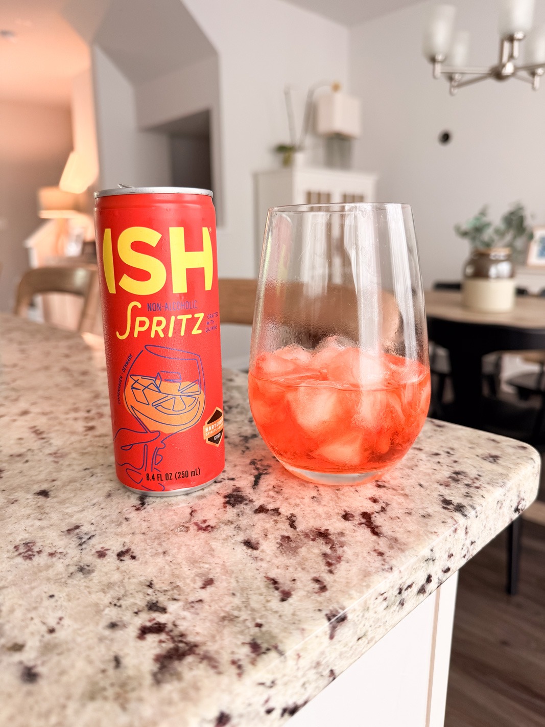Ish nonalcoholic aperol spritz in a can with a wine glass on ice
