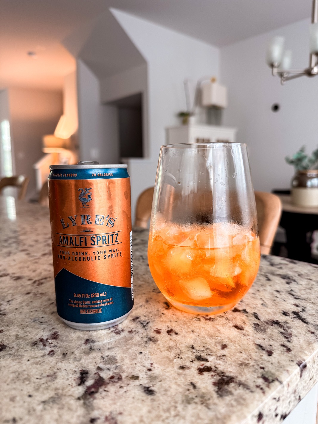 Lyre's nonalcoholic aperol spritz can with some in a wine glass on ice
